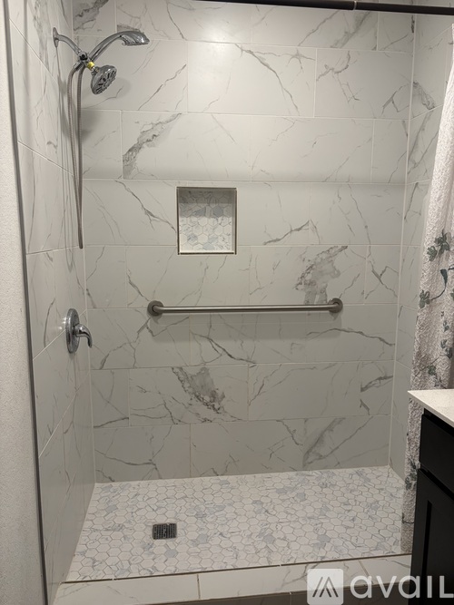 A bathroom with a marble tile shower.