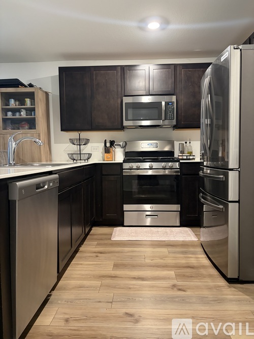 A kitchen with dark brown cabinets and stainless steel appliances.
