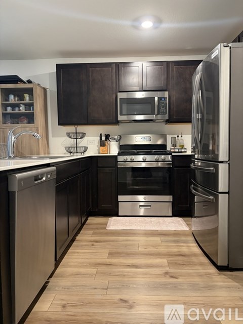 A kitchen with dark brown cabinets and stainless steel appliances.