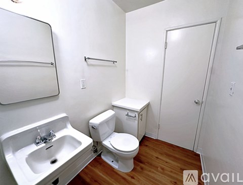 A white kitchen with a refrigerator on the right.