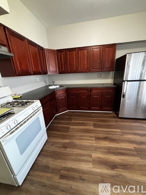 A kitchen with wooden cabinets and a white stove.