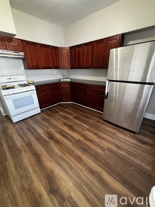 A kitchen with wooden cabinets and a white stove top oven.