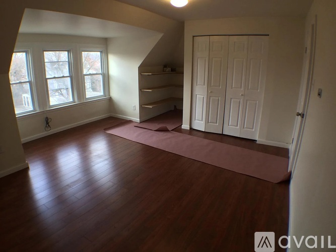 A room with wooden floors and a large window.