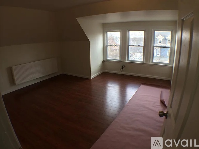 A room with a pink carpet and wooden flooring.