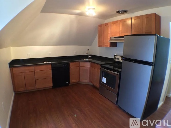 A kitchen with wooden cabinets and black countertops.