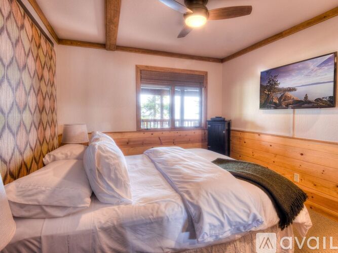 A bedroom with a large bed and a ceiling fan.