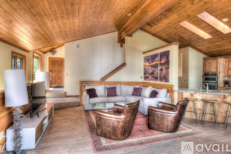 A living room with a wooden ceiling and a couch.