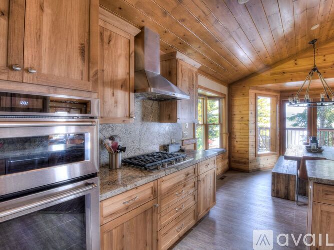 A kitchen with wooden cabinets and a stainless steel oven.