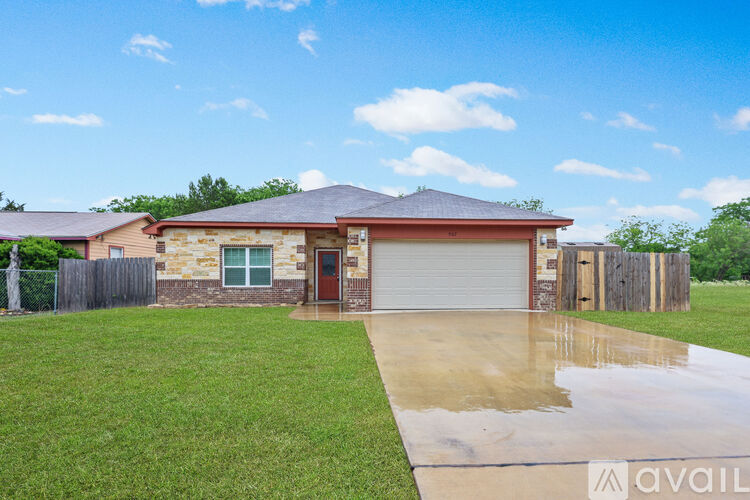 A house with a brown roof and a garage door is for sale.