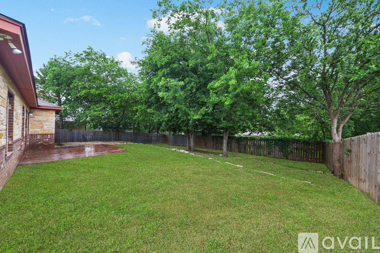 A backyard with a fence and trees.