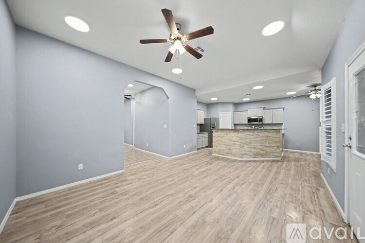 A spacious room with a ceiling fan and wooden flooring.