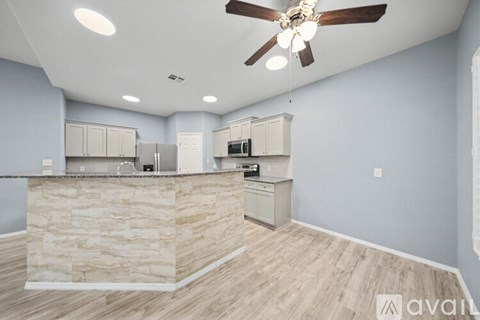 A kitchen with a stone counter and wooden flooring.