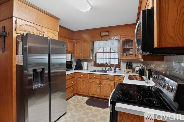 A kitchen with wooden cabinets and a stainless steel refrigerator.