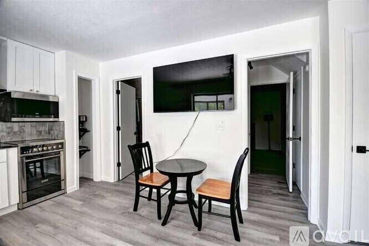 A kitchen with a table and chairs in the middle of the room.