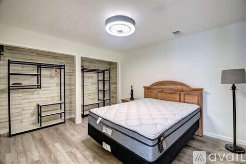 A bedroom with a bed, a wooden headboard, and a bunk bed with a ladder.