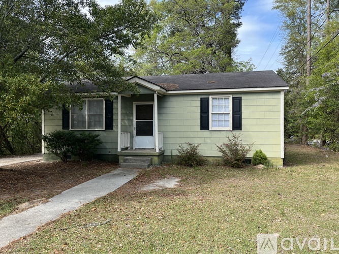 A small house with a porch and a front yard.