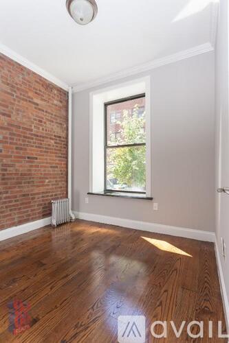 A room with a wooden floor and a window.
