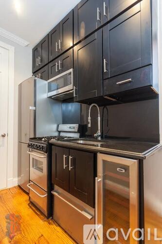 A kitchen with black cabinets and stainless steel appliances.