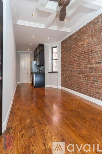 A room with wooden floors and a brick wall.