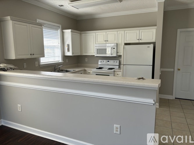 A kitchen with white appliances and cabinets.
