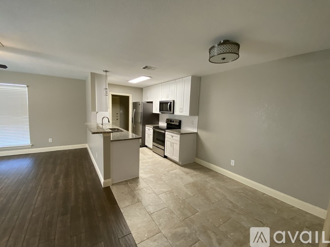 A kitchen with a refrigerator, microwave, and oven.