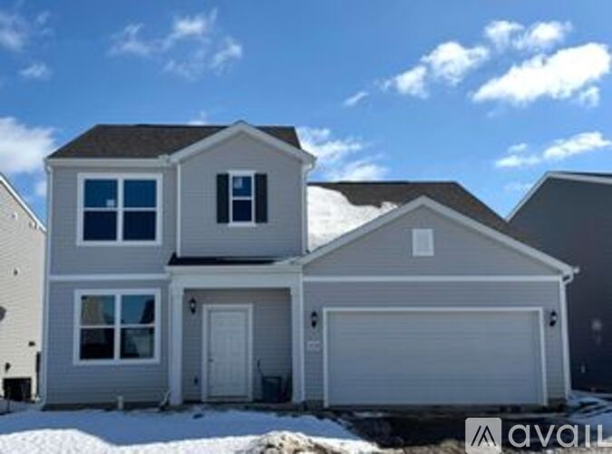A two-story house with a garage is available for sale.