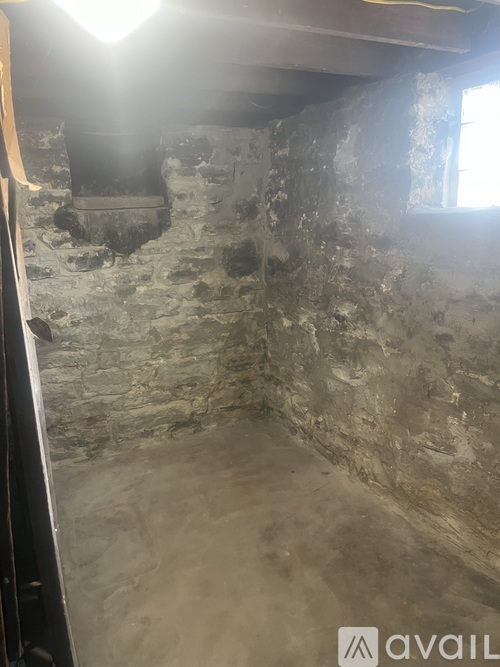 A room with a stone wall and a window.