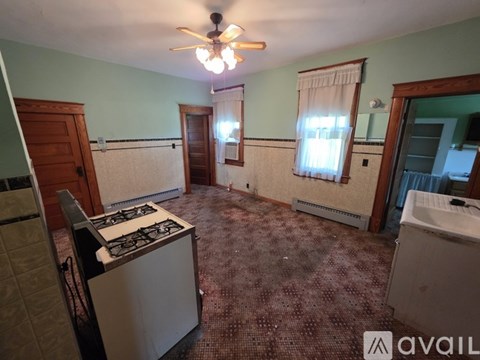 A kitchen with a stove, sink, and window.