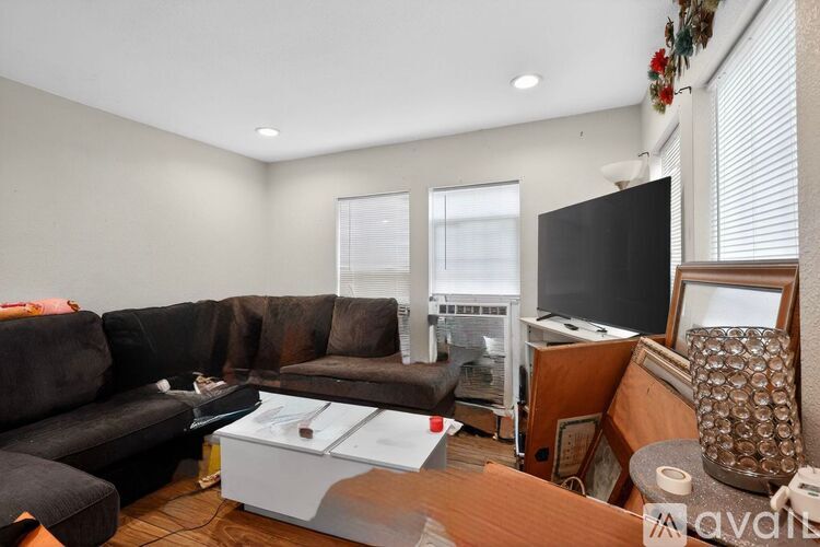 A living room with a couch, a coffee table, and a television.