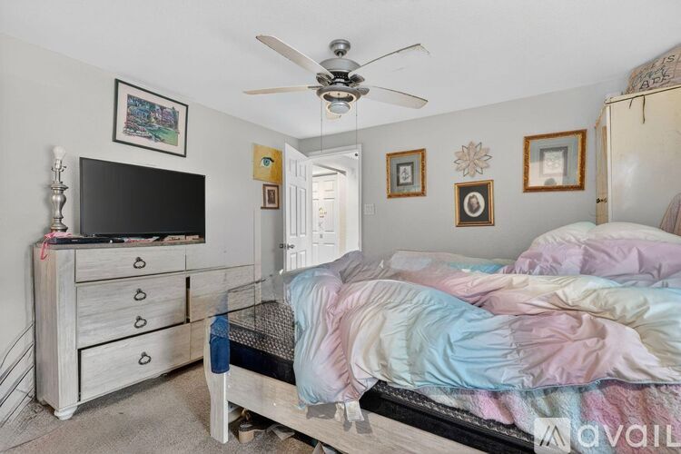 A bedroom with a bed, dresser, and television.