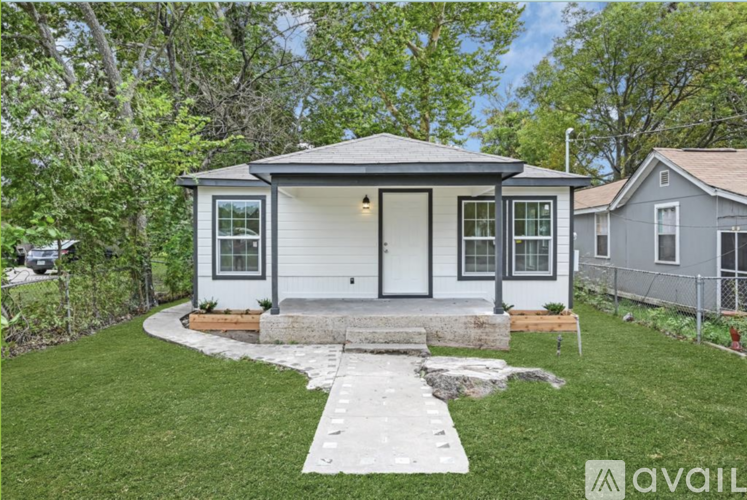A small house with a front yard and a walkway leading to the front door.