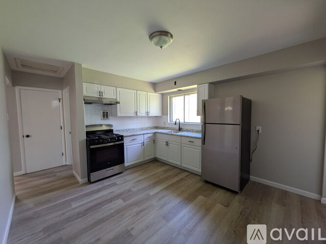 A kitchen with a refrigerator, oven, and sink.