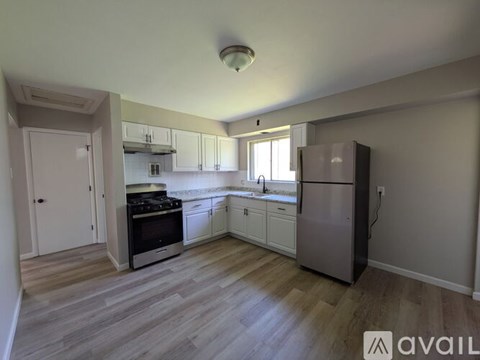 A kitchen with a refrigerator, oven, and sink.