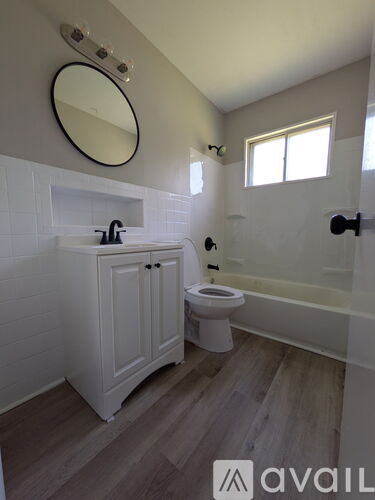 A bathroom with a toilet, sink, and mirror.