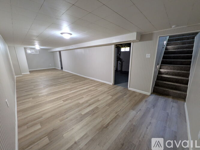 A room with wooden flooring and a staircase.