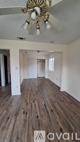 A room with a chandelier and wood flooring.
