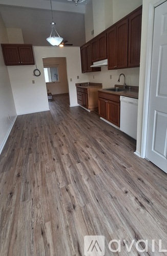 A kitchen with wooden floors and white appliances.