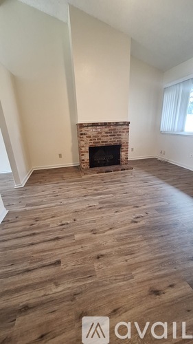 A room with a fireplace and wooden floors.
