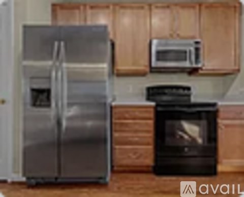 A silver refrigerator and a black oven in a kitchen.