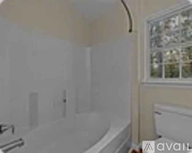 A bathroom with a tub and a window.