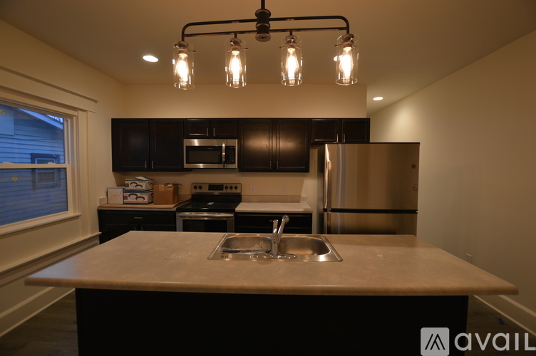 A kitchen with a sink, stove, and microwave.