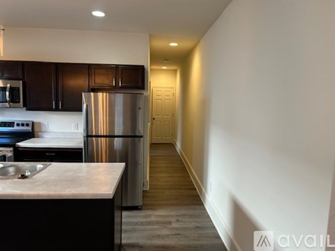 A kitchen with dark brown cabinets and a stainless steel refrigerator.