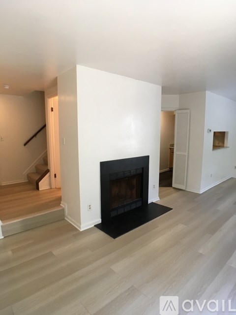 A modern living room with a fireplace and wooden flooring.