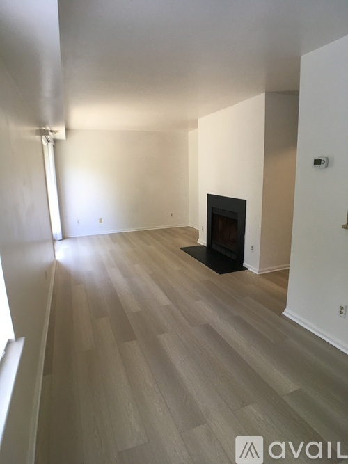 A room with a fireplace and wooden flooring.