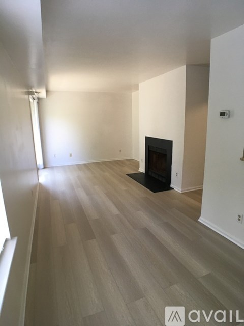 A room with a fireplace and wooden flooring.