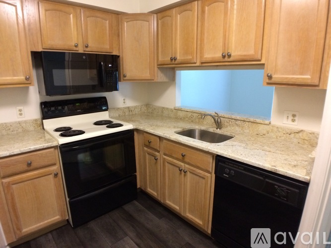 A kitchen with wooden cabinets and black appliances.