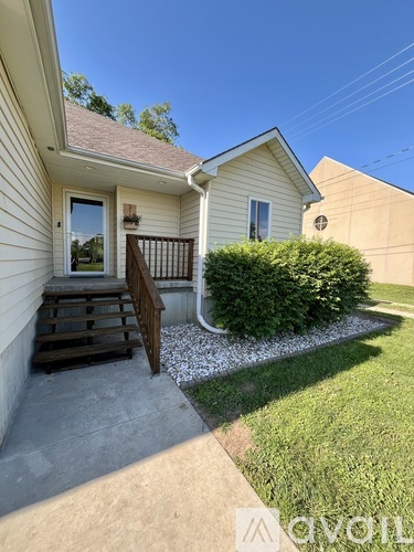 A house with a front yard and a bush.