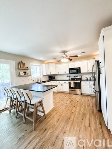 A kitchen with white cabinets and a black countertop.