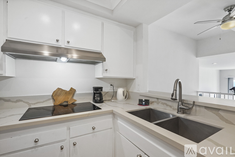 A kitchen with white cabinets and a stainless steel range hood.