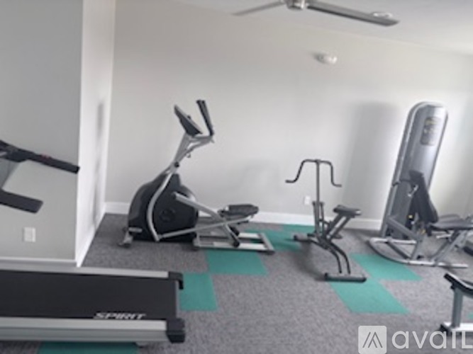 A gym with a treadmill, exercise bike, and other equipment.